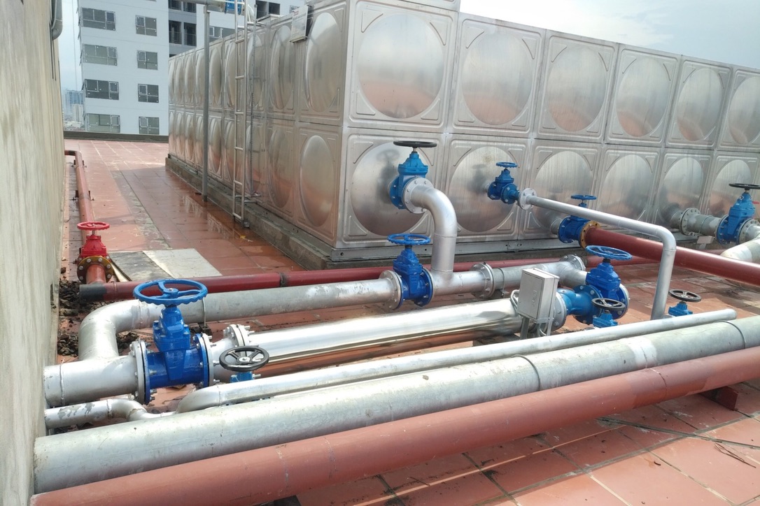 Hệ ống Dileka 200 bằng inox lắp trên sân thượng tòa căn hộ The Legacy Hà Nội, cạnh bồn nước inox